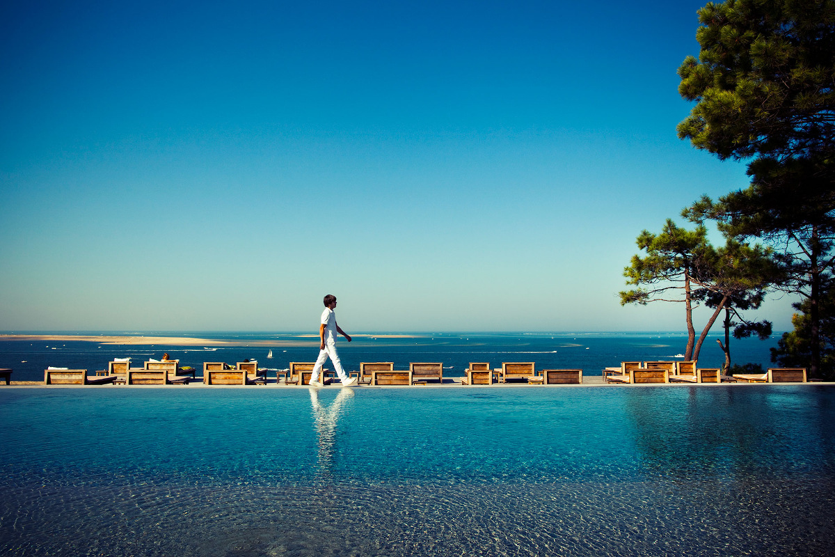 A man walking along the edge of a swimming pool